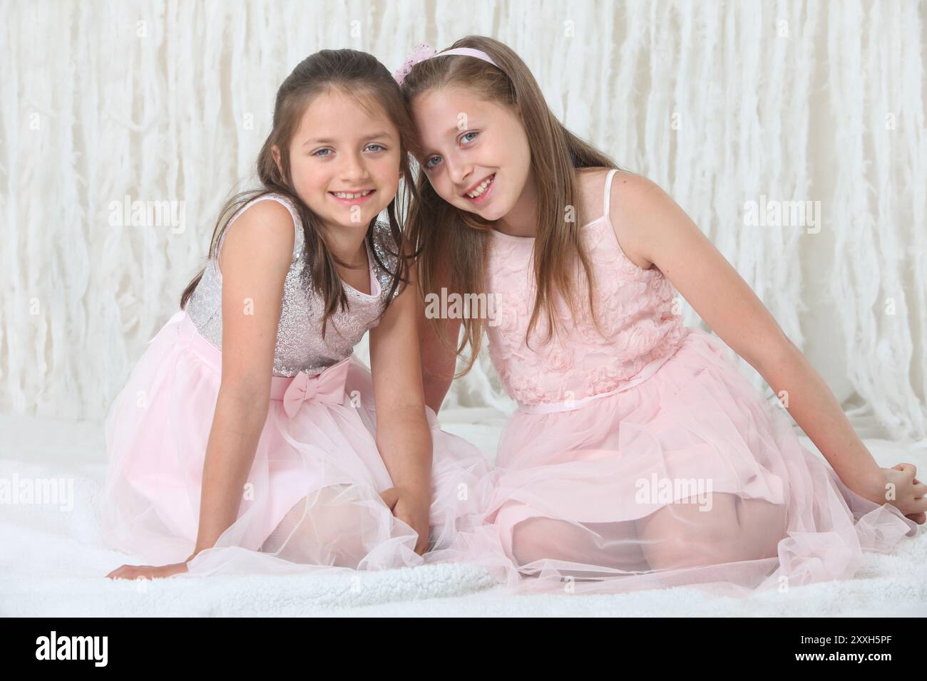 portrait of two pretty cheerful preteen girls in elegant dresses on ...