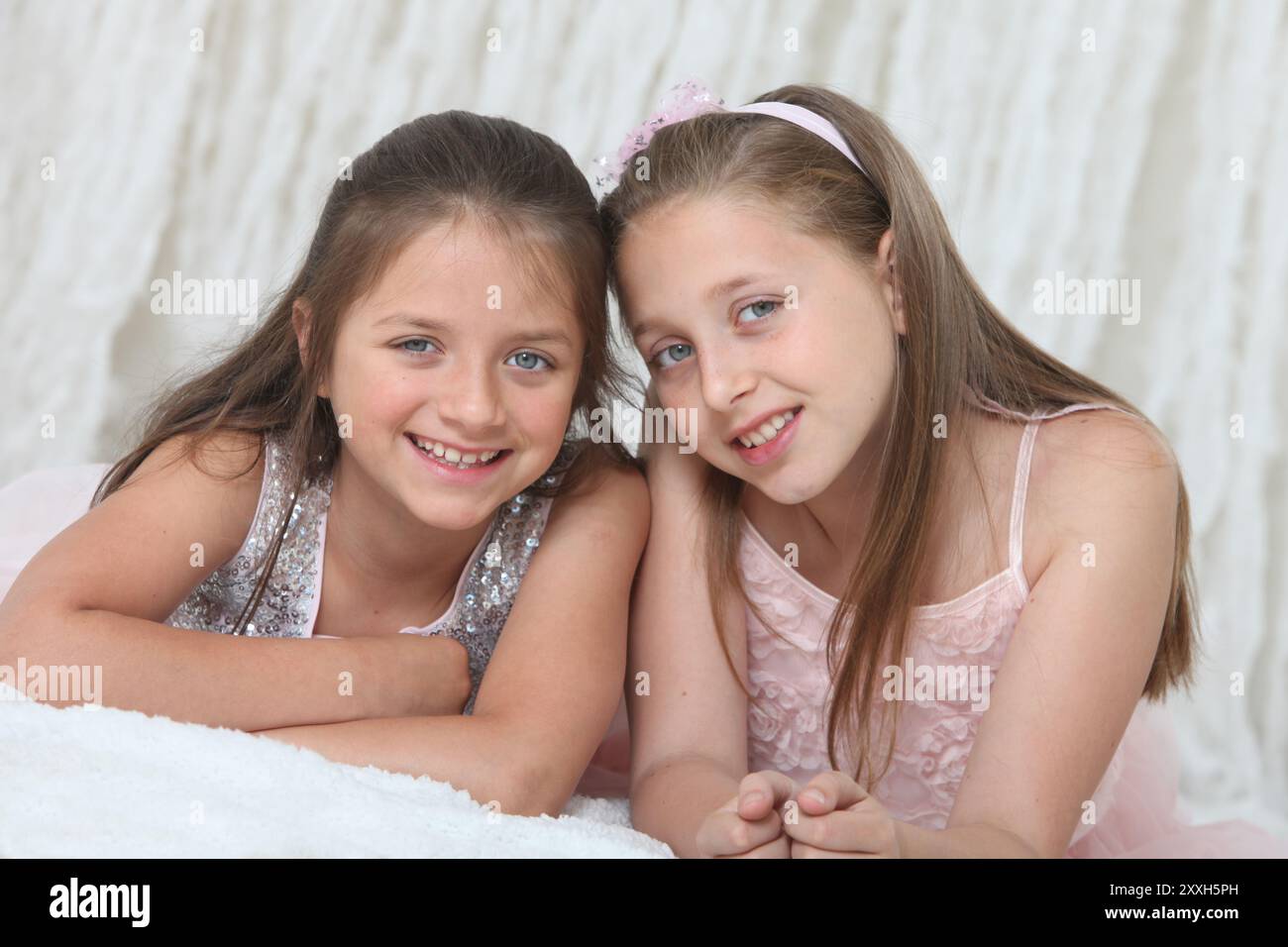 portrait of two pretty cheerful preteen girls in elegant dresses on ...