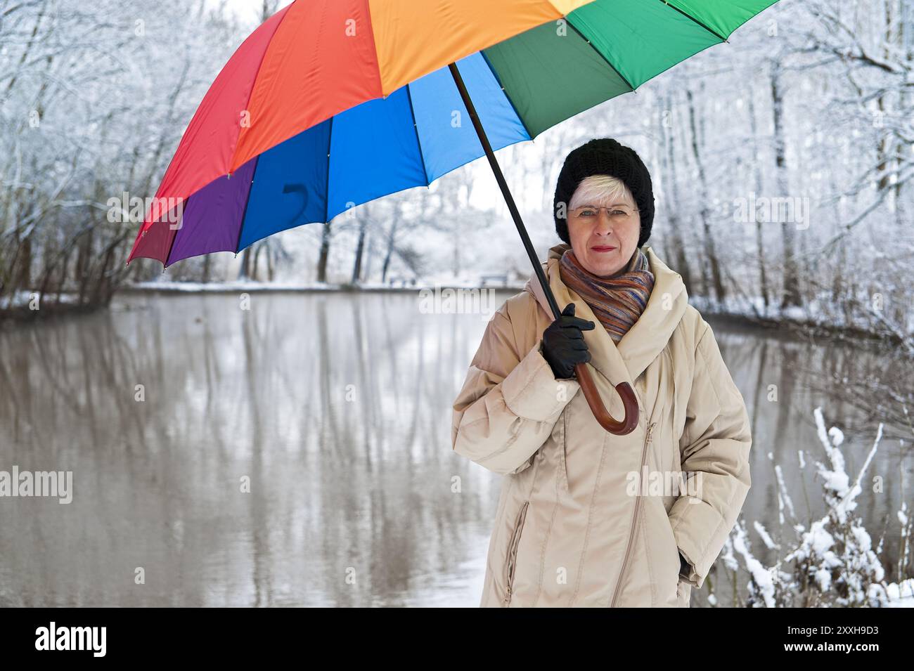 Woman with a colourful umbrella stands on the riverbank Stock Photo - Alamy