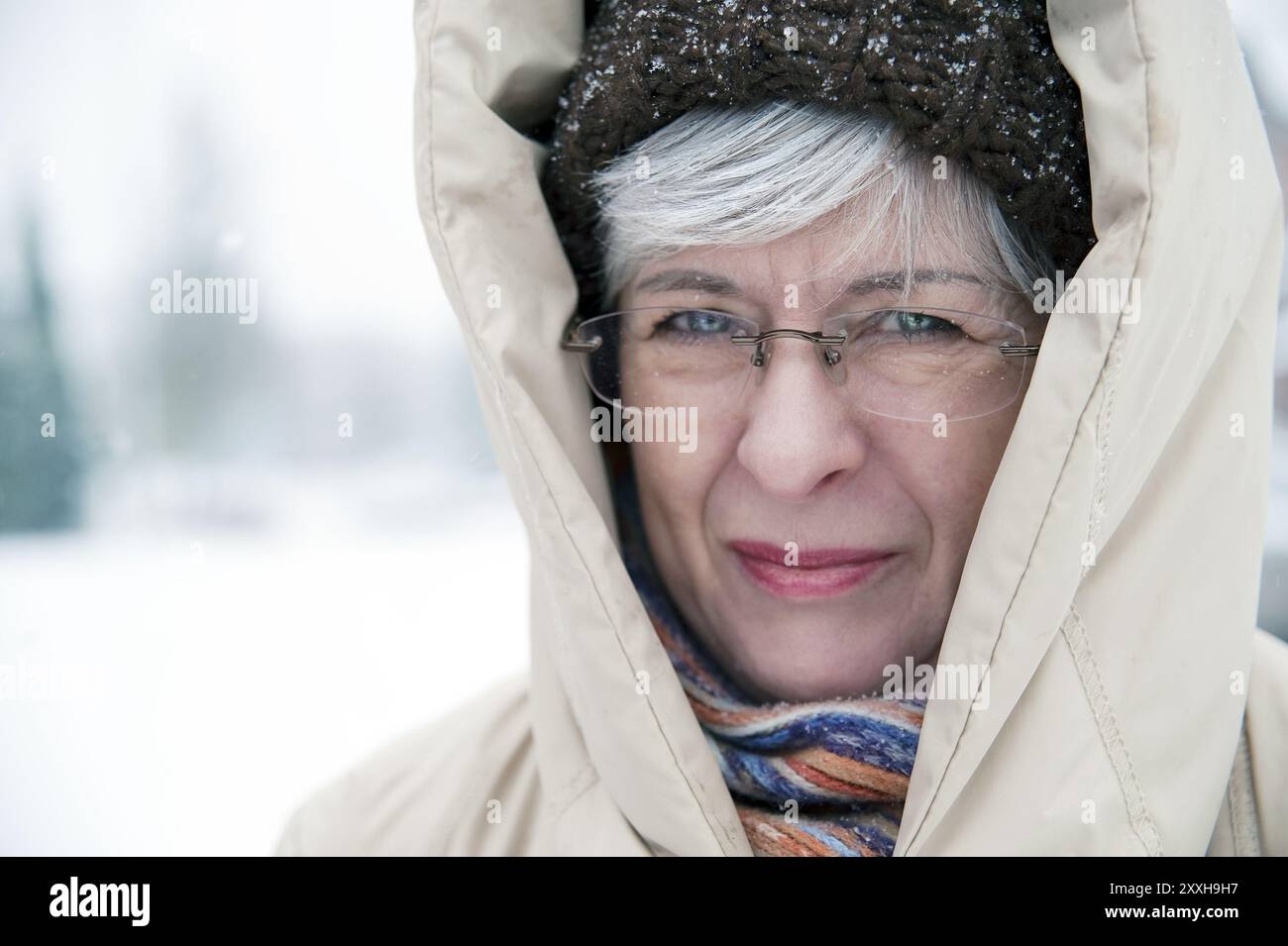 Woman, 50+, with cap and hood in winter Stock Photo