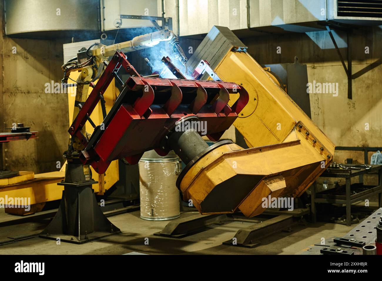 Industrial machine operating inside factory with metal panel attached ...