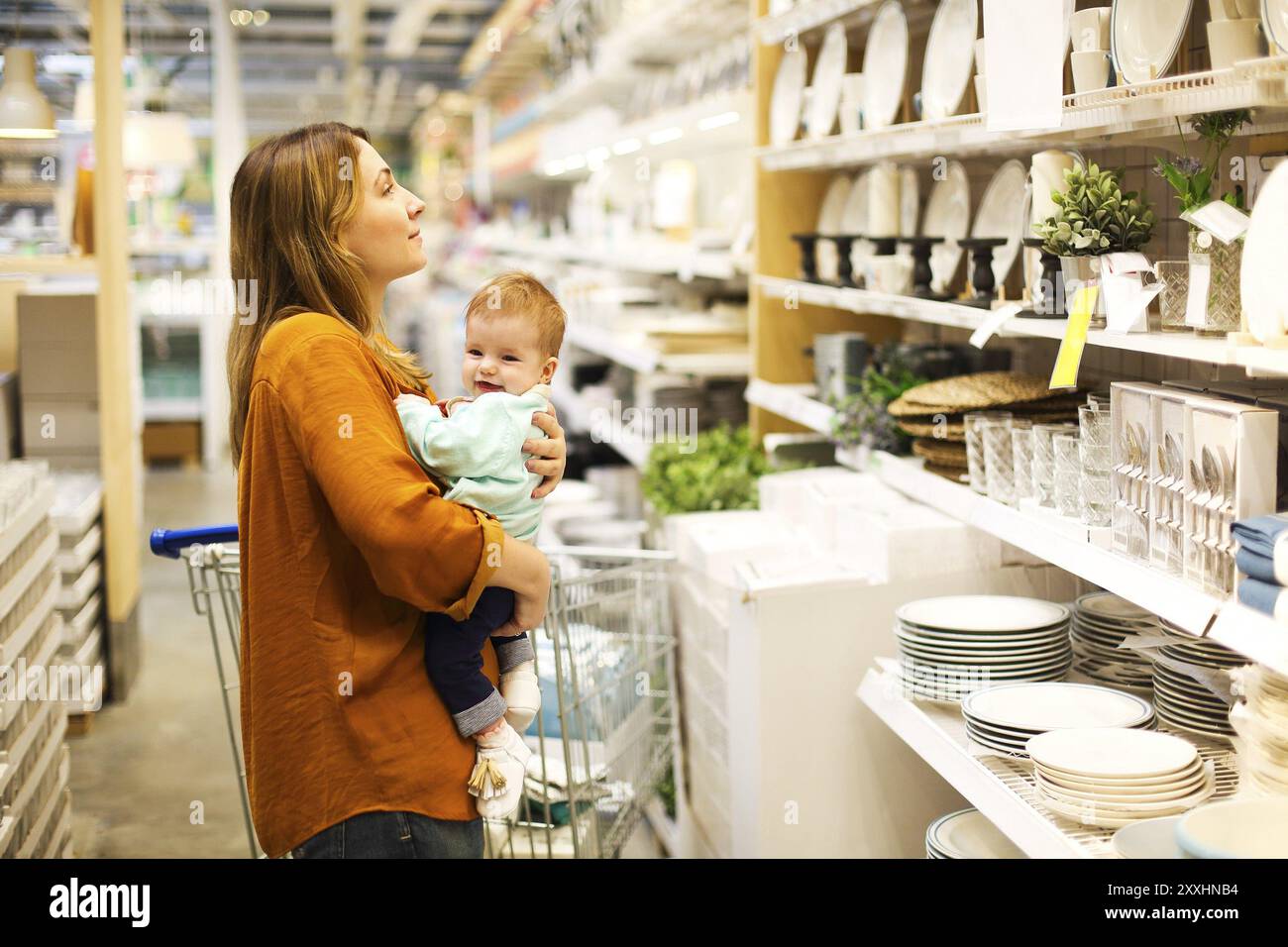 Young mother with her little baby girl at the supermarket together Stock Photo