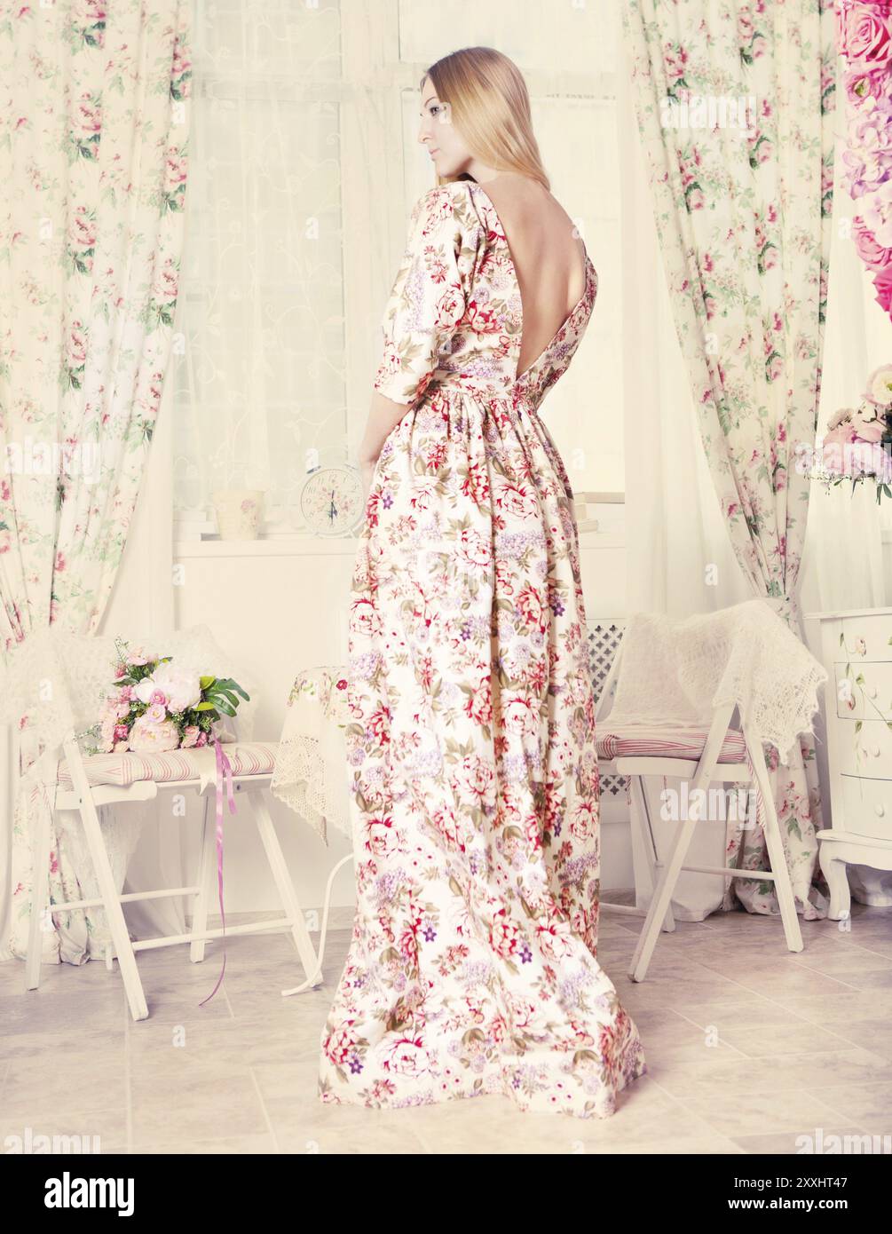 Portrait of the beautiful blond girl in long dress in living room Stock ...