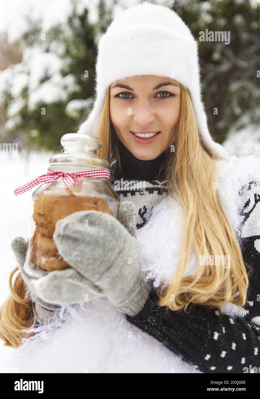 Smiling woman holding cookies jar in her hands outdoors Stock Photo