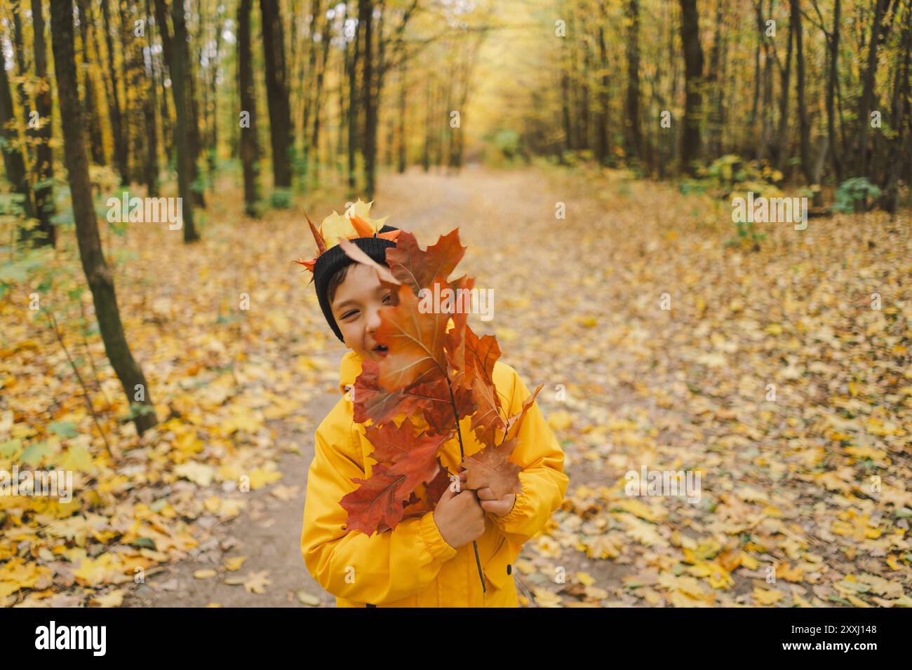A cheerful child in a yellow raincoat walks through the forest Stock ...
