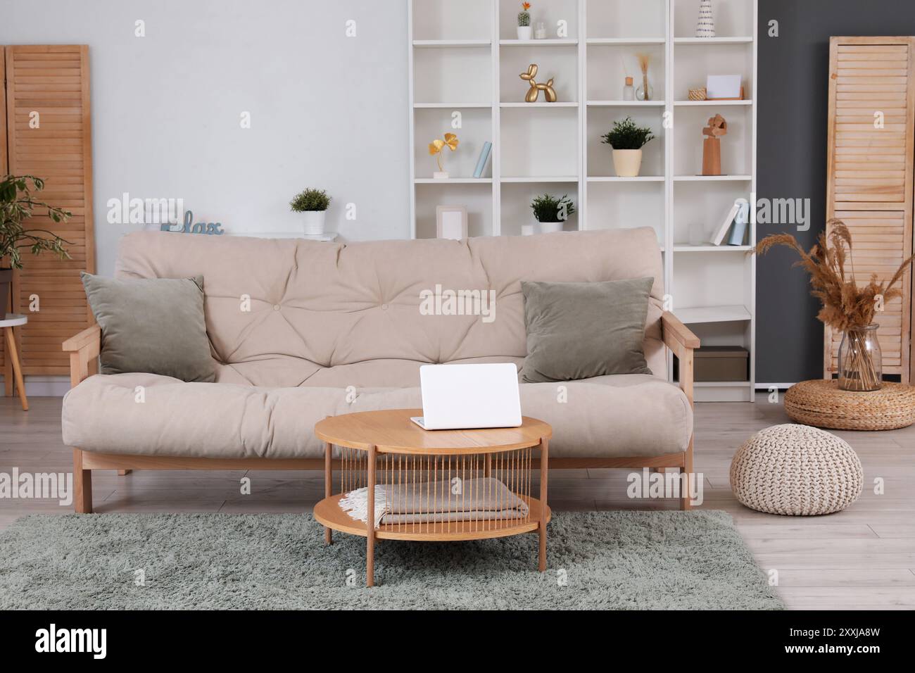 Interior of light living room with cozy sofa, coffee table and shelving ...