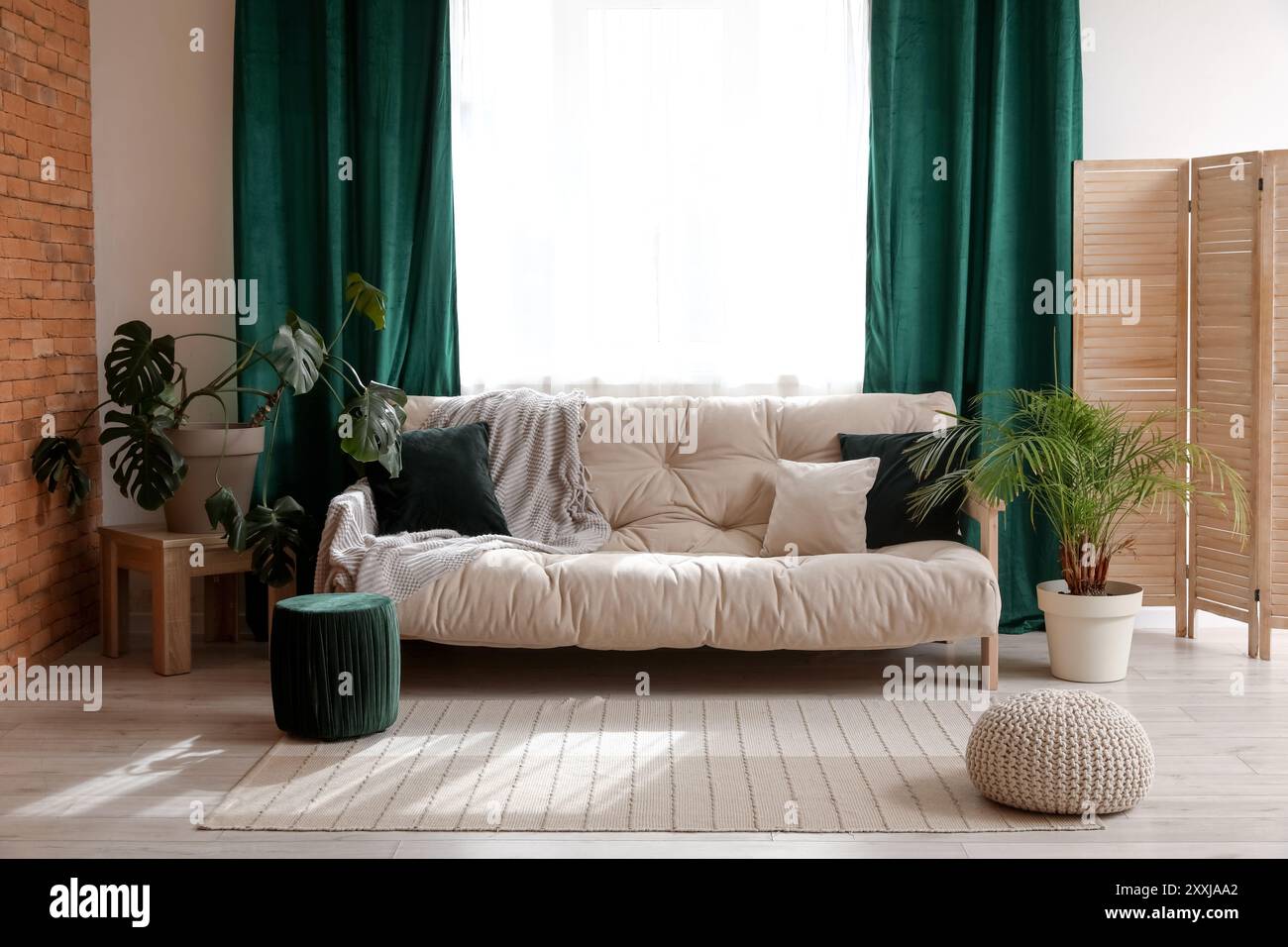 Comfortable sofa near window with green curtains in living room Stock Photo