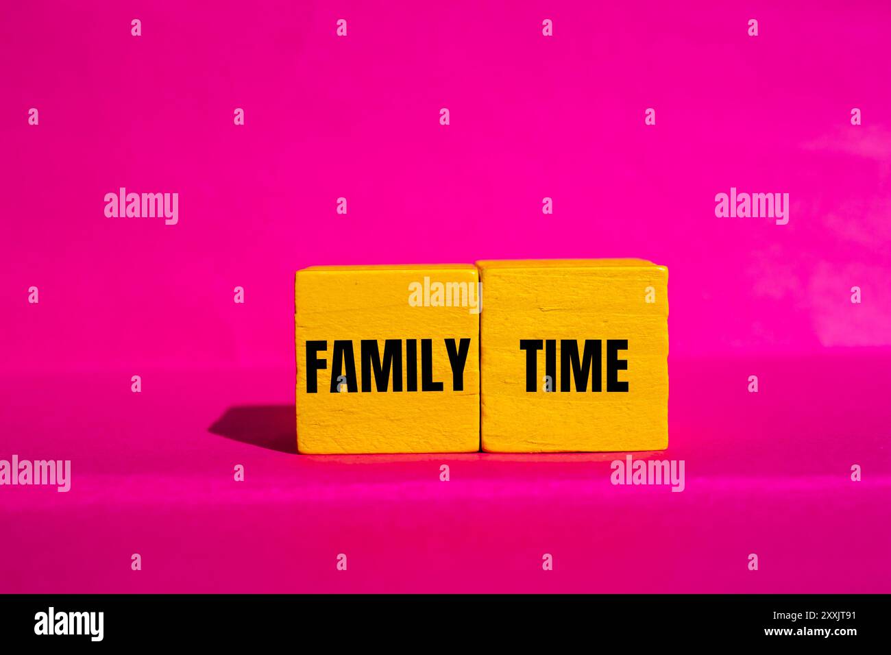Family time message written on yellow wooden cubes with pink background ...