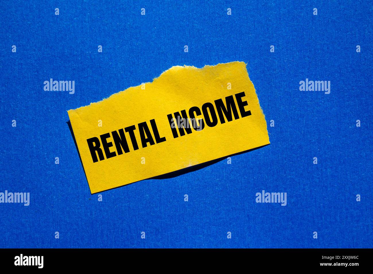 Rental income message written on ripped torn yellow paper piece with ...