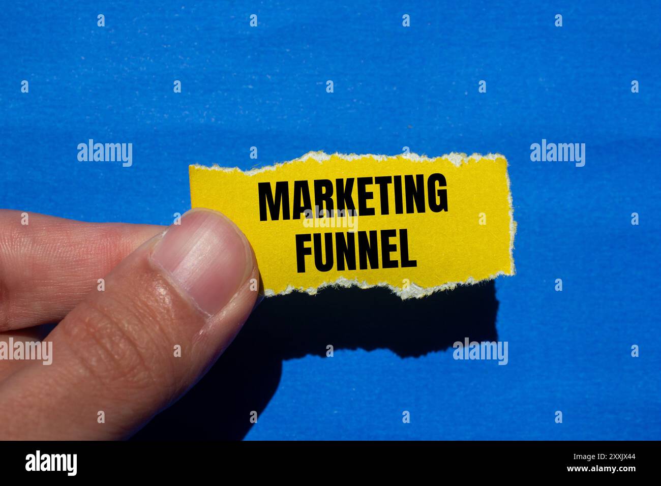 Marketing funnel message written on ripped torn yellow paper with blue ...