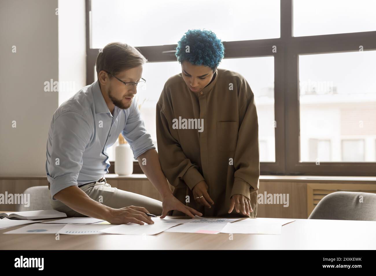 Two multiethnic colleagues working together in office Stock Photo