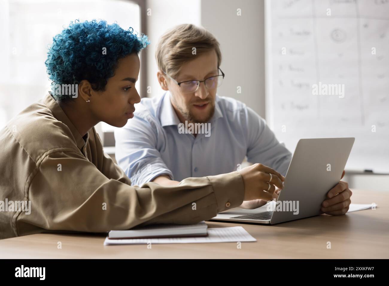 Colleagues learning new corporate program working together using laptop Stock Photo