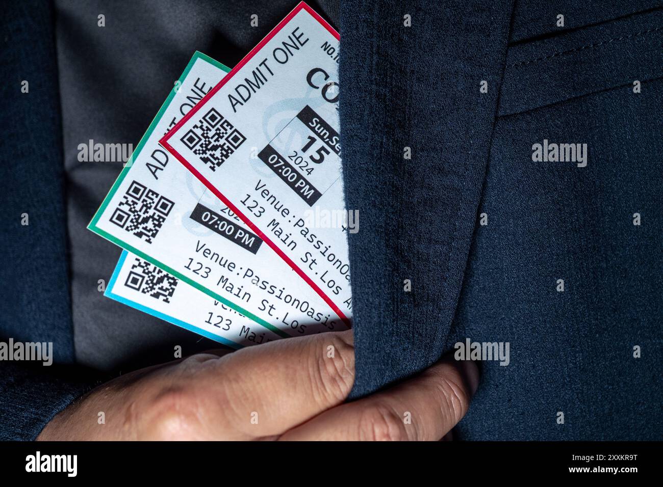 A hand extracts three concert tickets from a pocket, a common tactic used in ticket scalping Stock Photo