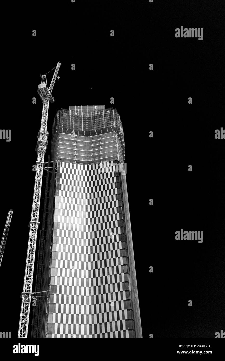 A Black and white photo of a tall modern building under construction at ...