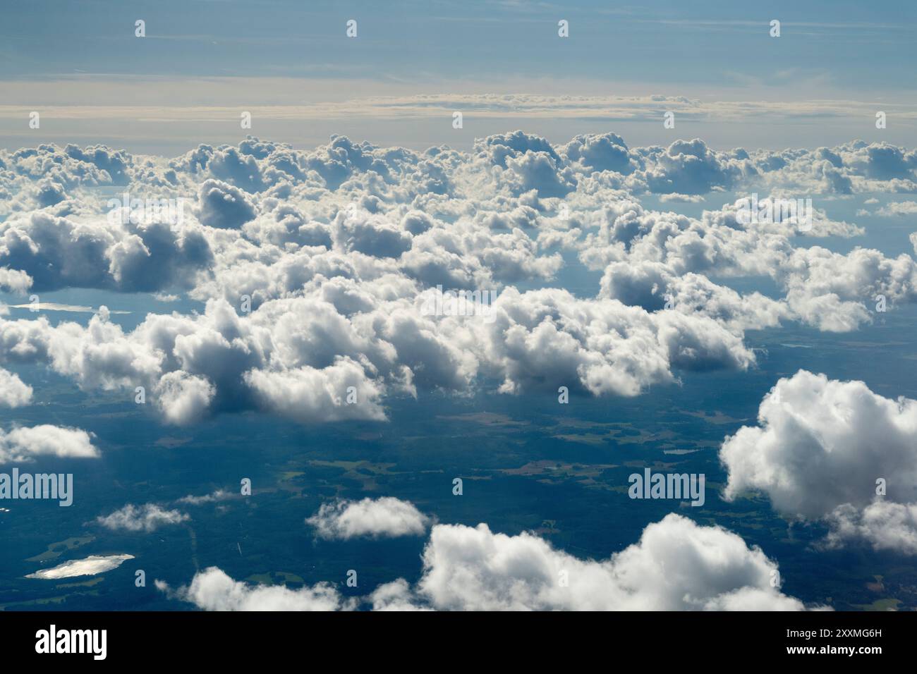 aerial view of fluffy white clouds casting shadows on the landscape ...