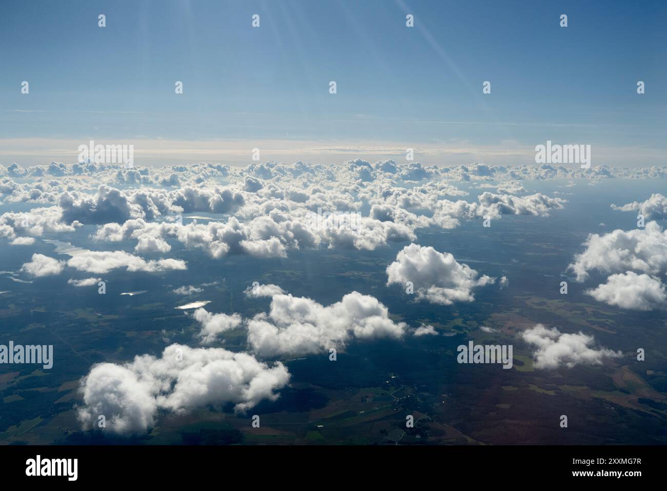 aerial view of fluffy white clouds casting shadows on the landscape ...