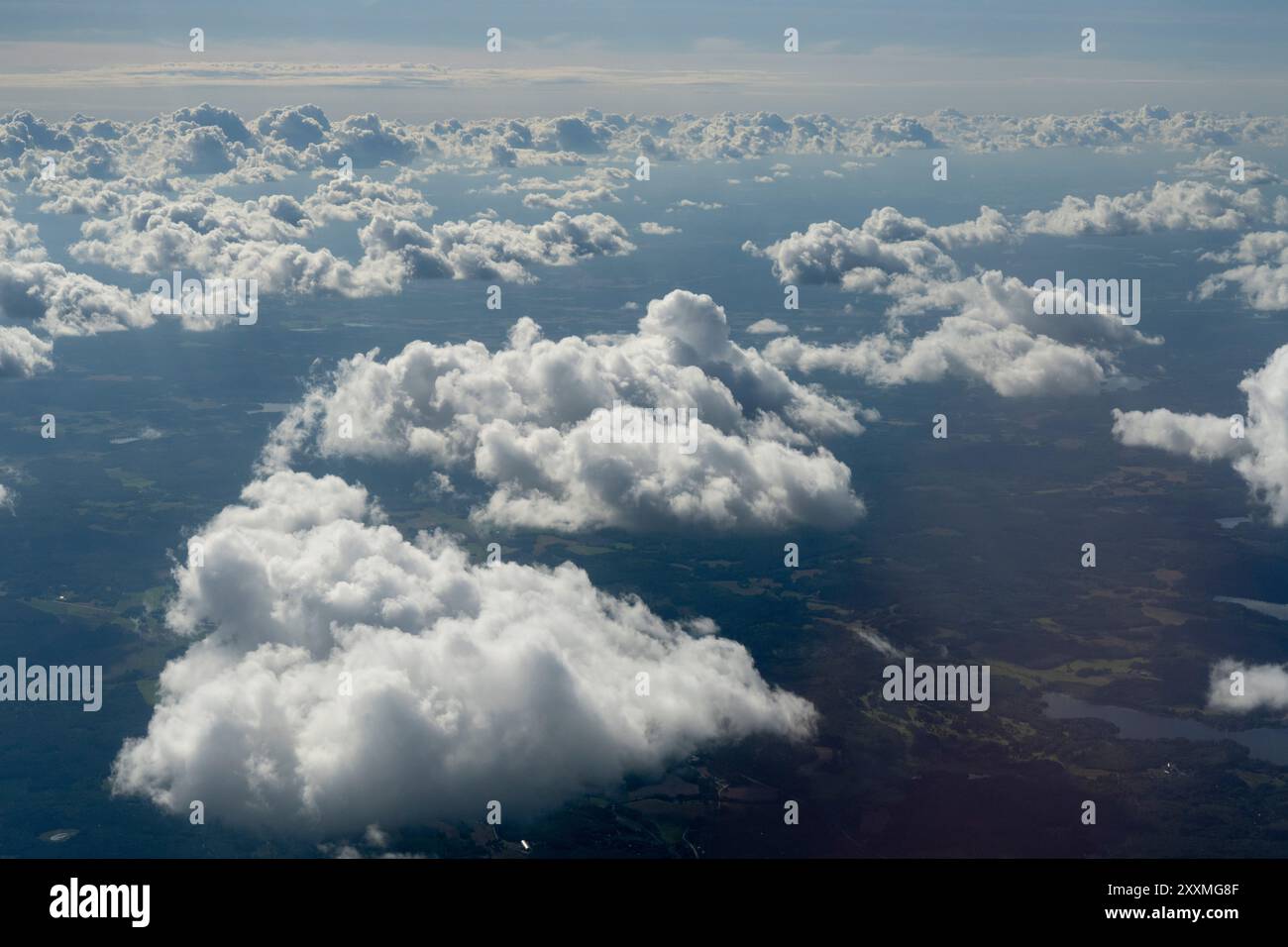 aerial view of fluffy white clouds casting shadows on the landscape ...