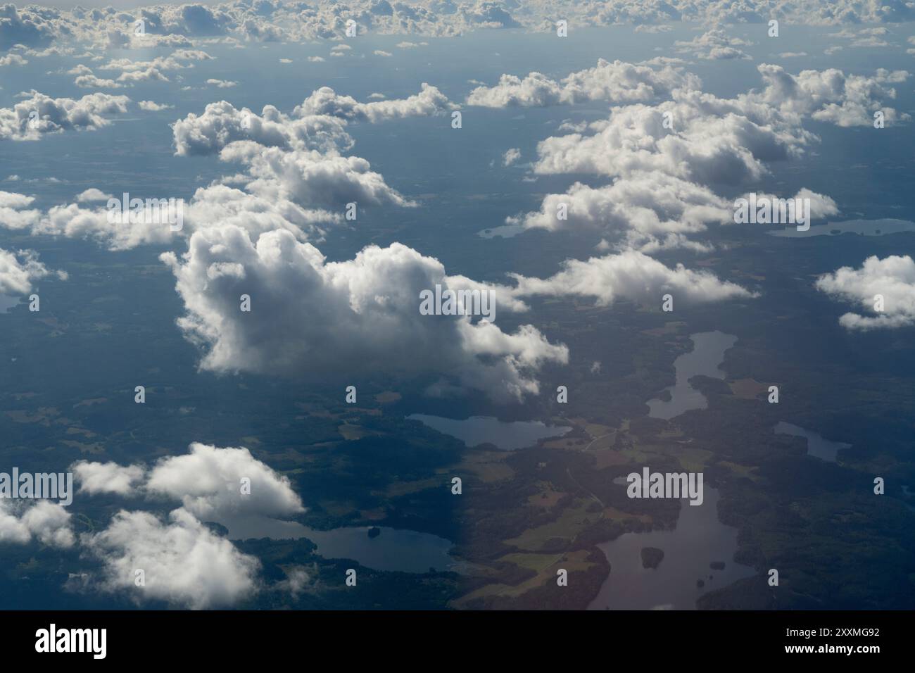 aerial view of fluffy white clouds casting shadows on the landscape ...