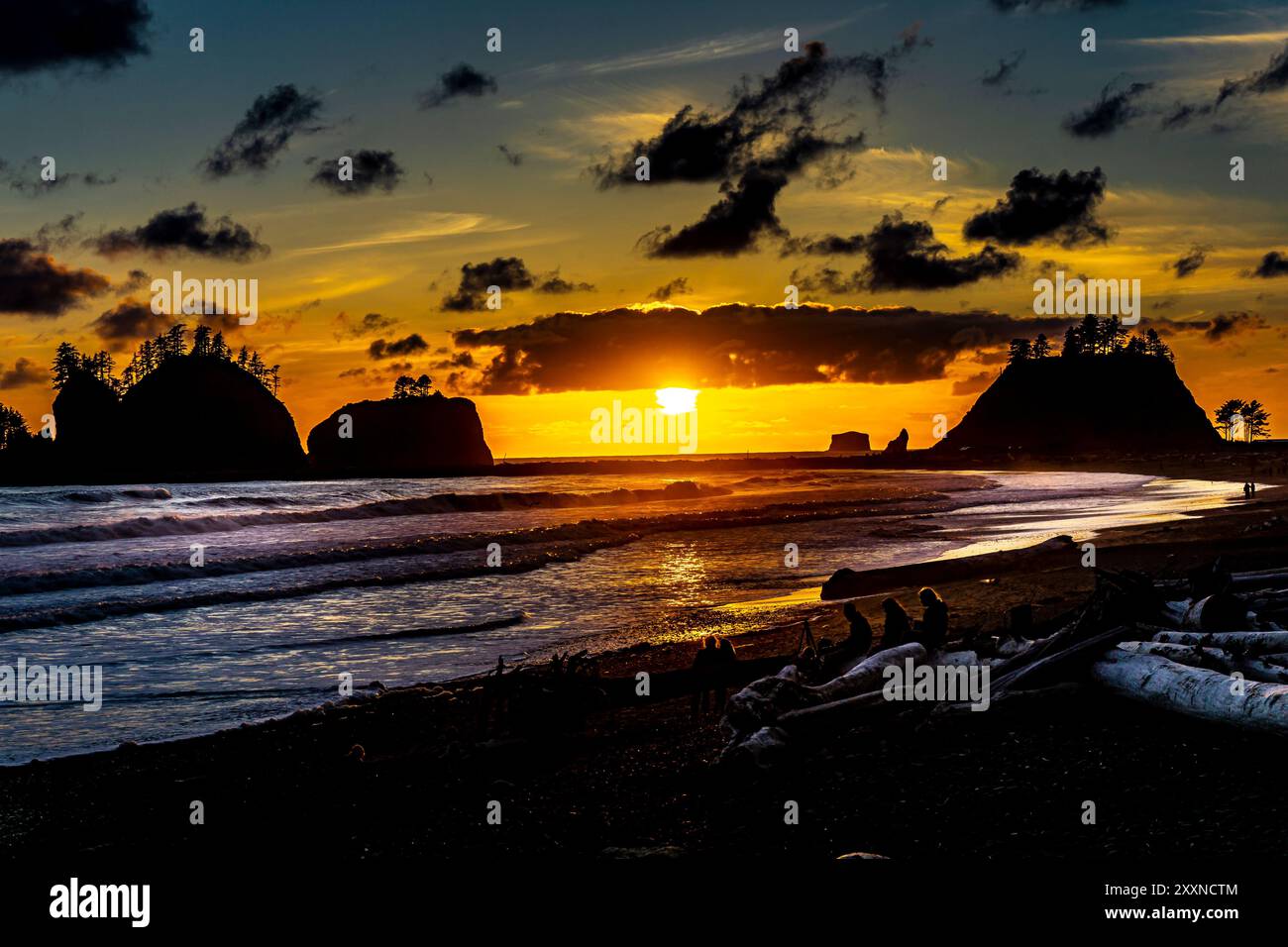 At the Quileute Oceanside Resort in La Push, Washington, looking North along the shore at dusk.  A beautiful bright sunset through a few clouds. Stock Photo