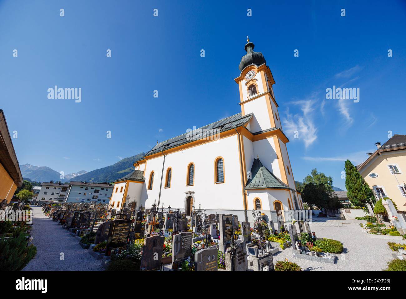 Baroque exterior of Pfarrkirche St. Leonhard (parish church of St Leonard) and churchyard in Mittersill village, Pinzgau region of the Alps, Austria Stock Photo