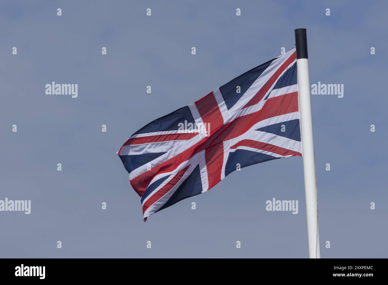 Union jack flag of the United Kingdom blowing in the wind against a ...