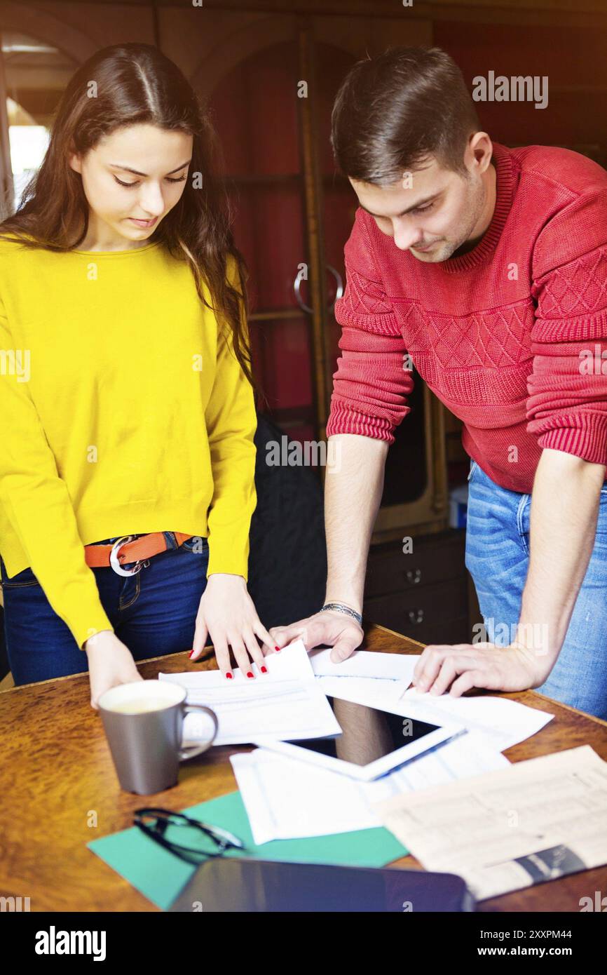 Business team at work with financial reports and a tablet computer Stock Photo