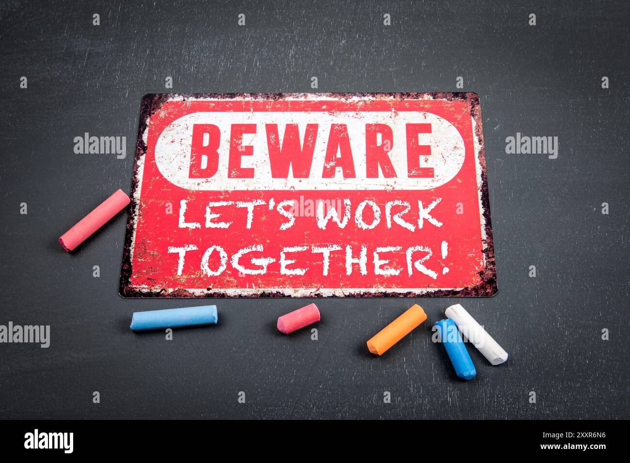 Let's Work Together . Beware sign with text and colored pieces of chalk ...