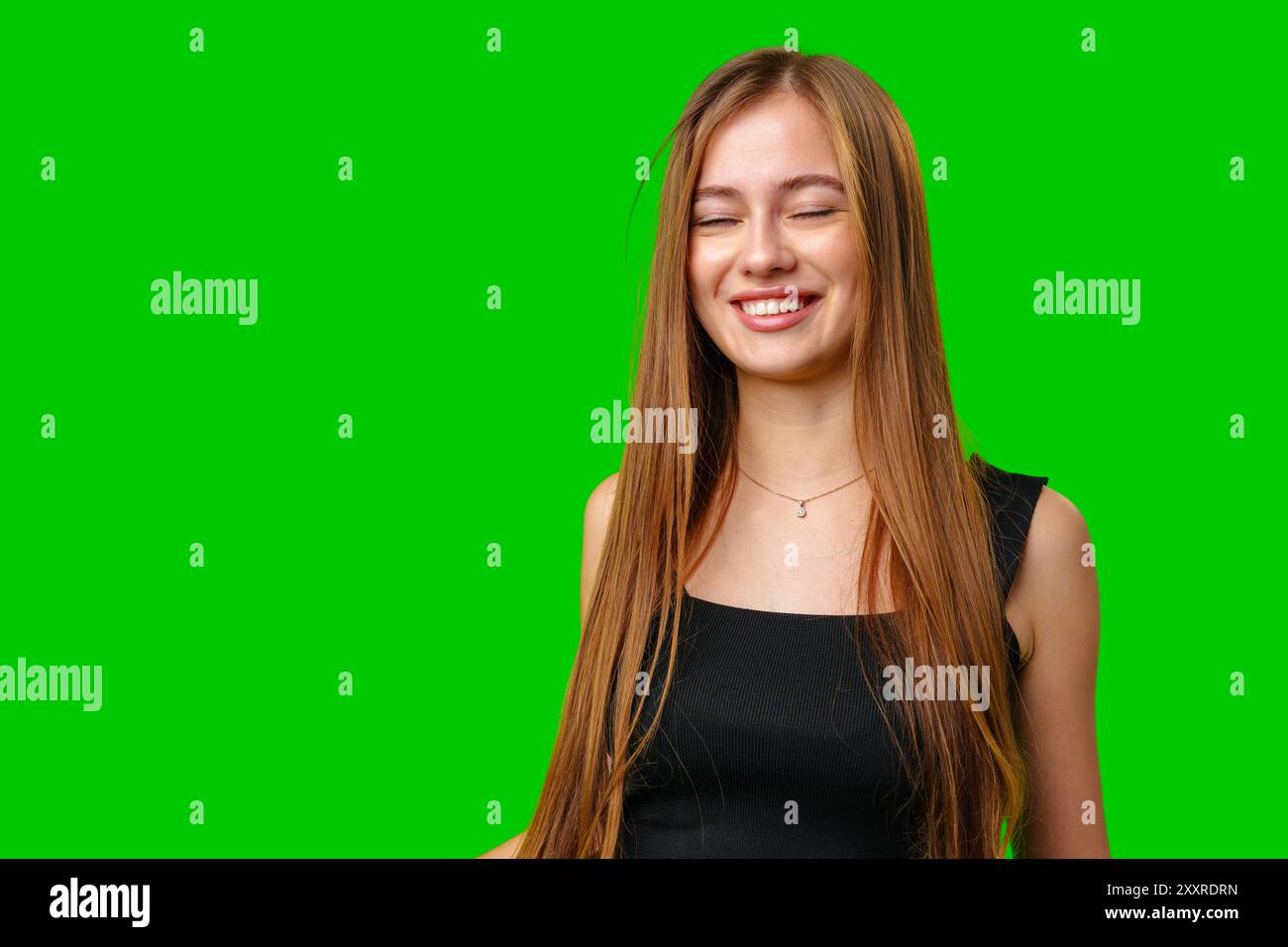 Portrait of a Smiling Young Woman With Long Brown Hair Against a Green ...