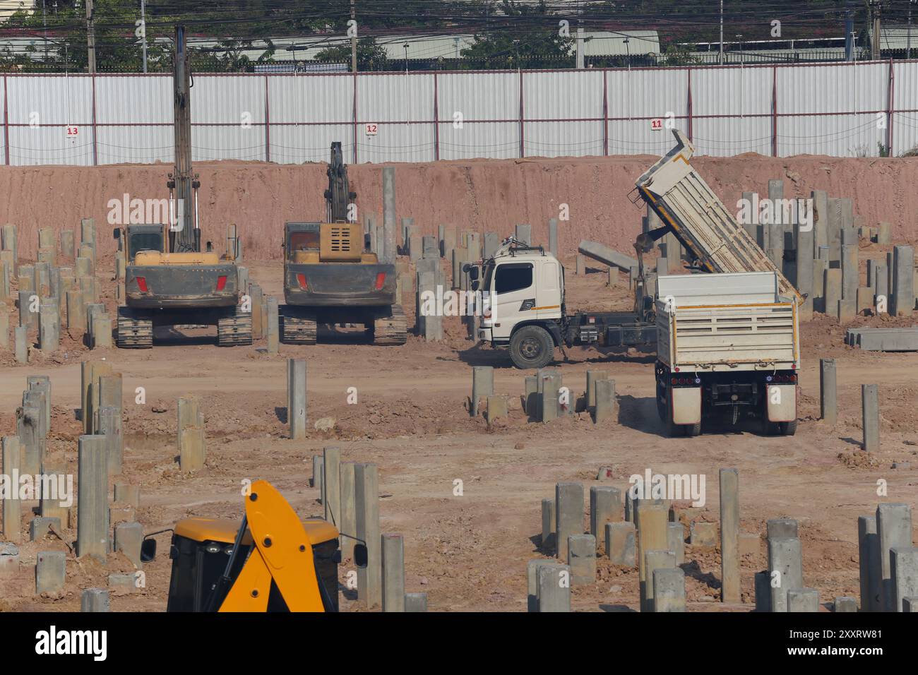 Construction work zones of piling where piles are driven into the ground for large construction projects with stable foundations. Stock Photo