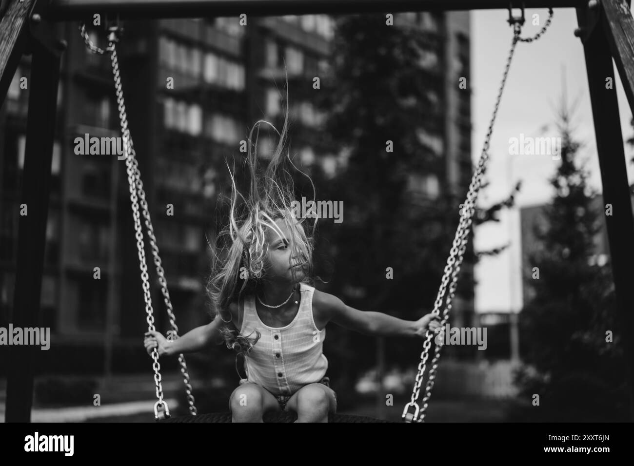 Girl with blowing hair on a swing Stock Photo - Alamy