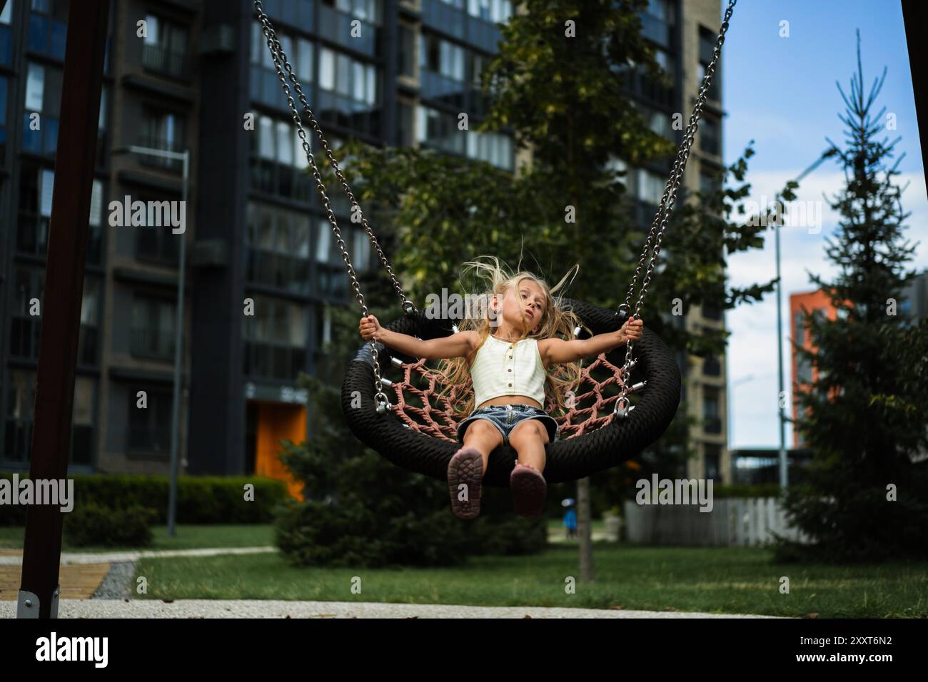 Girl with blowing hair on a swing Stock Photo - Alamy