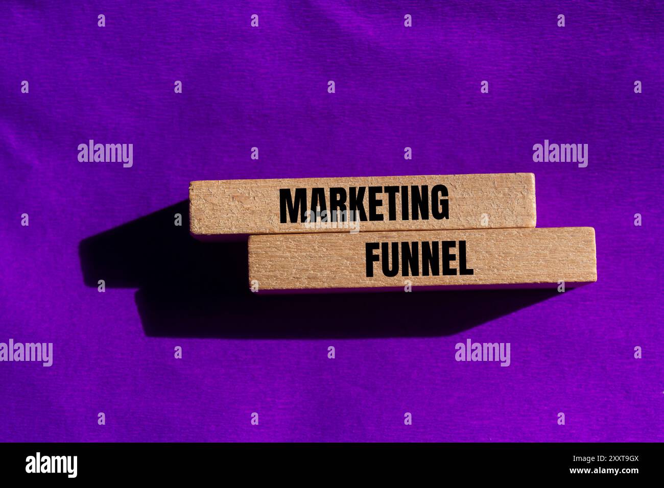 Marketing funnel message written on wooden blocks with purple background Stock Photo