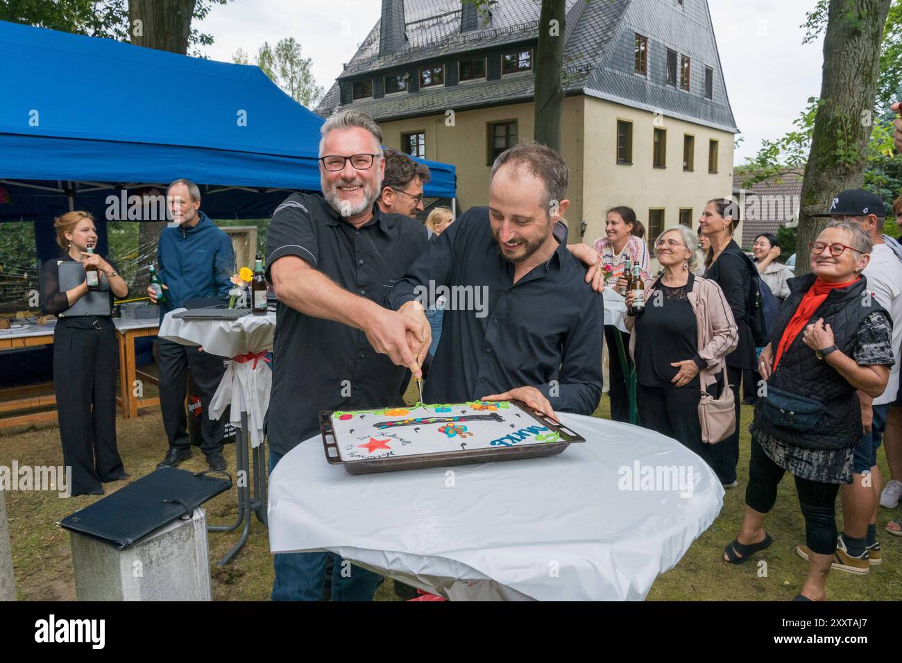 Niederwürschnitz, 25.8.24 Im Rahmen seiner 12 Sommergesang-Konzerte für bürgerschaftliche Kulturinitiativen singt der MDR-Rundfunkchor in der St. Johanneskirche im erzgebirgischen Niederwürschnitz. Der Verein, Die Kulturelle Notlösung e. V., gewann unter 120 Einsendern der Radiokampagne Sommergesang. Manuela Malecki verfasste die erfolgreiche Bewerbung für ihren Verein. Dirigent Gregor Meyer führt durch das besucherstärkste Konzert. Zum Abschluss singen Chor und Gäste das Steigerlied. Ein deutsche Bergmanns- und Volkslied, das traditionell stehend gesungen wird. Gemeinsam schneiden Vereinsvors Stock Photo