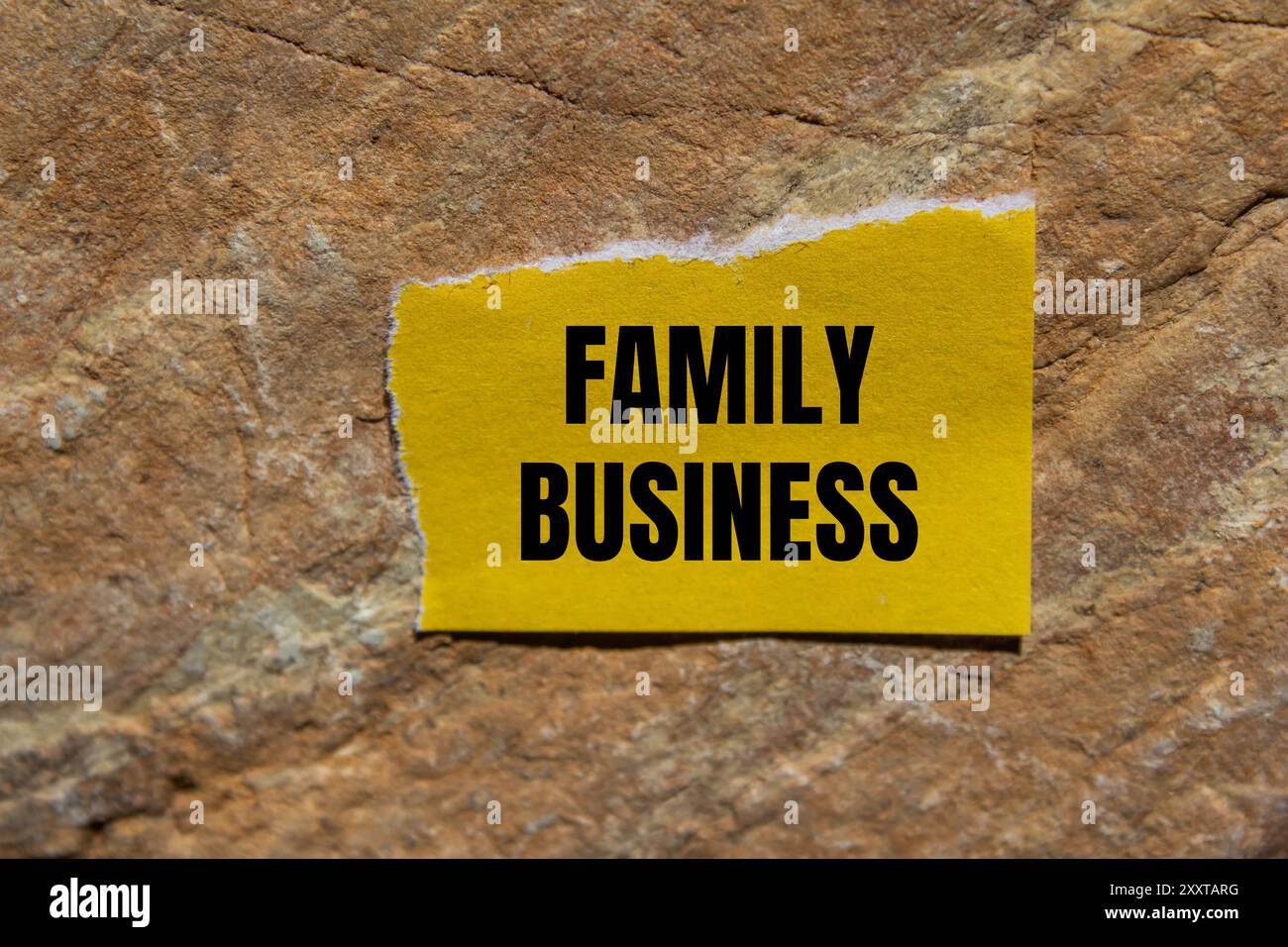 Family business message written on ripped torn yellow paper piece with ...
