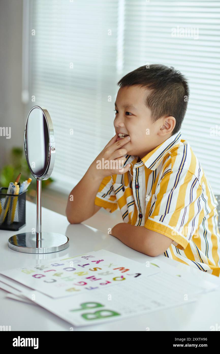 Examining Reflection in Mirror at Study Desk Stock Photo - Alamy