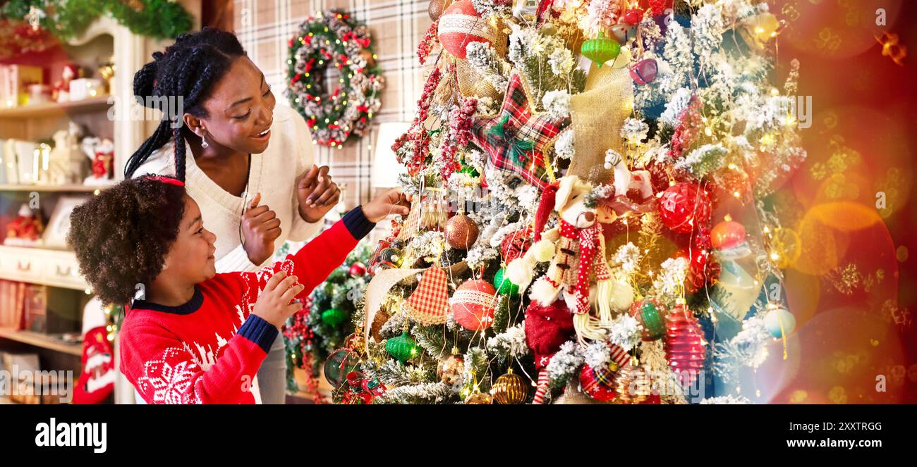 Adorable little afro girl decorating Christmas tree with her mom Stock ...