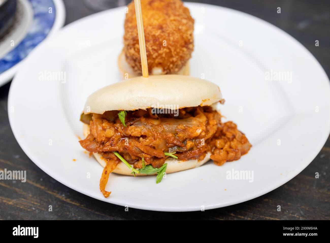 A plate of delicious tapas showing a Chicken tikka masala in a bao bread Stock Photo