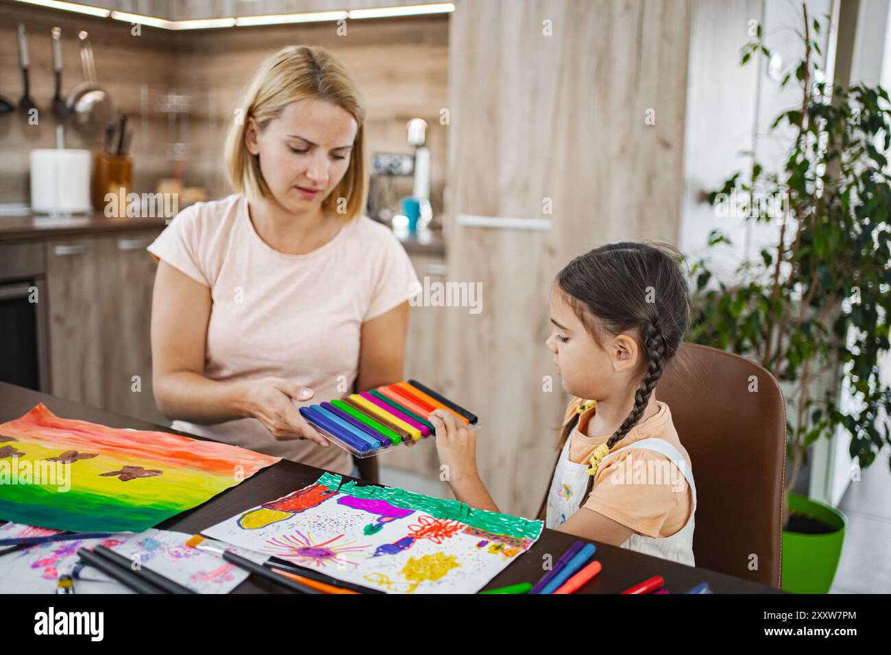 Mother and daughter engage in creative art activity at home Stock Photo ...
