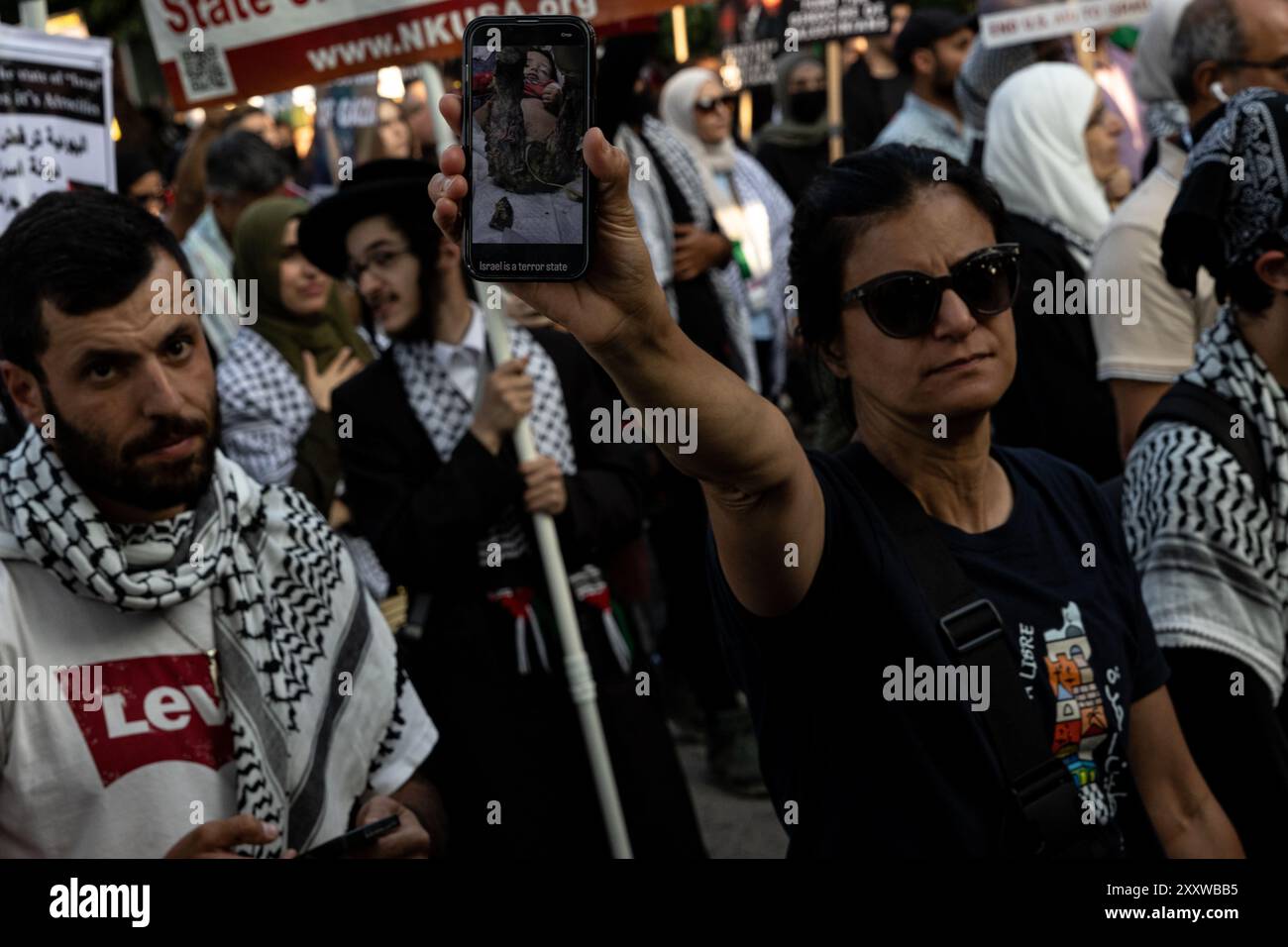 Chicago, USA. 21st Aug, 2024. A woman shows a picture of an child injured by Israeli bombing in Gaza during a protest outside the Democratic National Convention in Chicago, IL on Wednesday, August 21, 2024. Thousands of pro-Palestine activists participated in the marches and protests held throughout the week of the DNC to protest United States' support for Israel and demand a ceasefire to the war in Gaza. Credit: Sipa USA/Alamy Live News Stock Photo