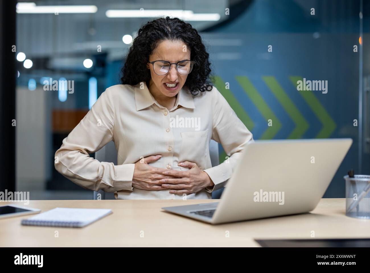 Office worker feeling discomfort from stomach pain while working on ...