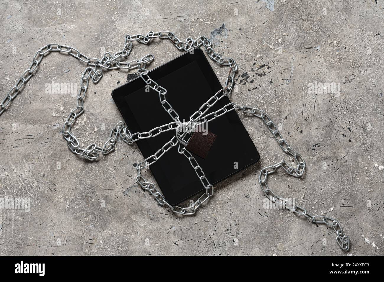 Tablet computer with padlock and chains on grunge background. Cyber security concept Stock Photo