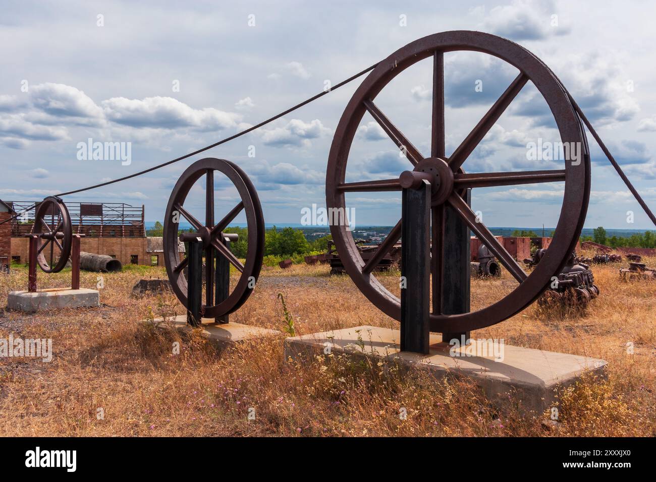 Old pulley wheel and cable at a former mine. Stock Photo