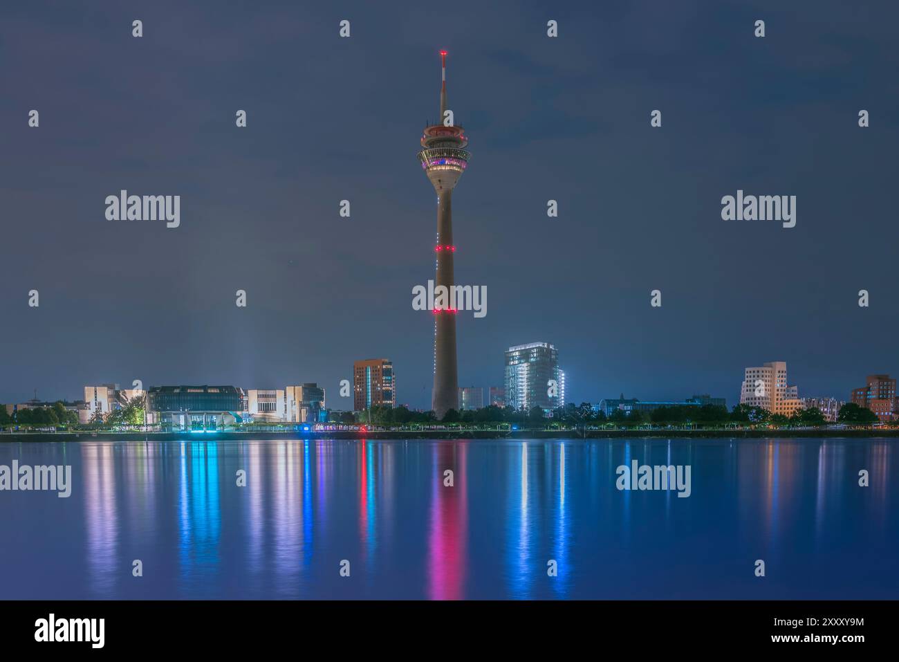 Night View over the river rhine of the 240.5m tall Düsseldorf TV Tower "Rheinturm" with its surrounding buildings in the "Medienhafen" district Stock Photo