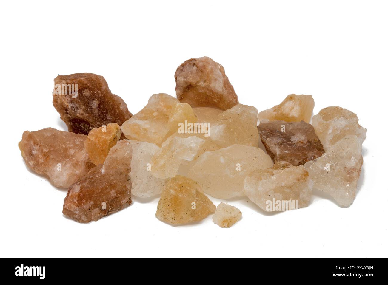 Salt stones of different colours piled up in front of a white ...