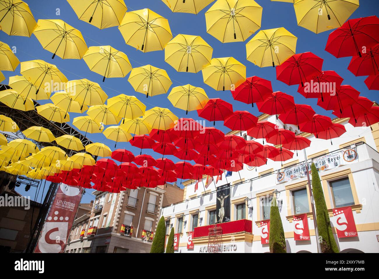 Madrid, Spain. 26th Aug, 2024. Umbrella-shaped ornament with the colors of the Spanish flag adorn the town hall square of San Sebastian de los Reyes, Madrid. As every year, the Madrid town of San Sebastian de los Reyes has started this morning the celebration of its patron saint festivities and as part of them its bull runs and bullfights. Credit: SOPA Images Limited/Alamy Live News Stock Photo