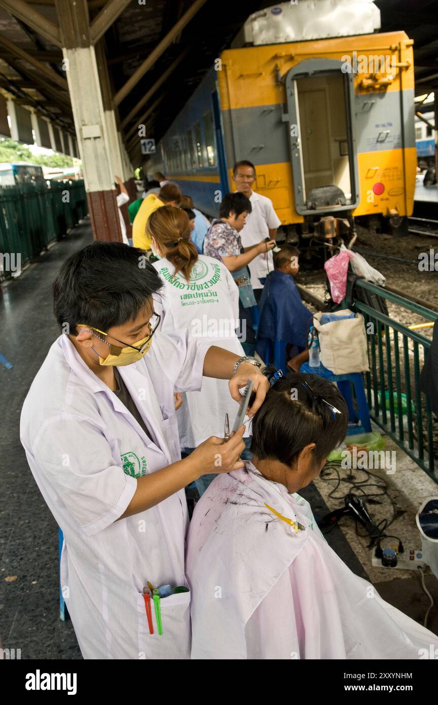 Free haircut on the platform in Bangkok's Hua Lamphong railway station in Bangkok, Thailand. Stock Photo