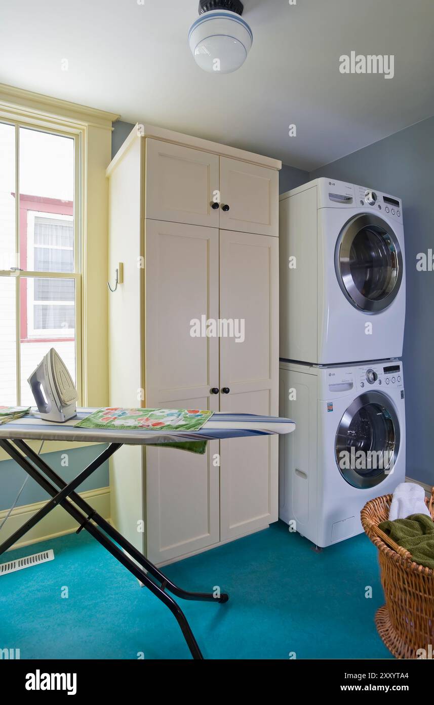 Colorful remodeled laundry room in Victorian house with ironing board ...