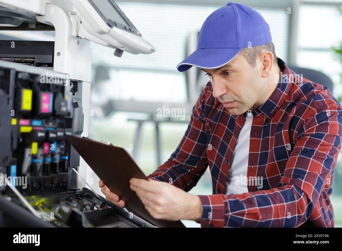 technician using clipboard to fix a printer Stock Photo