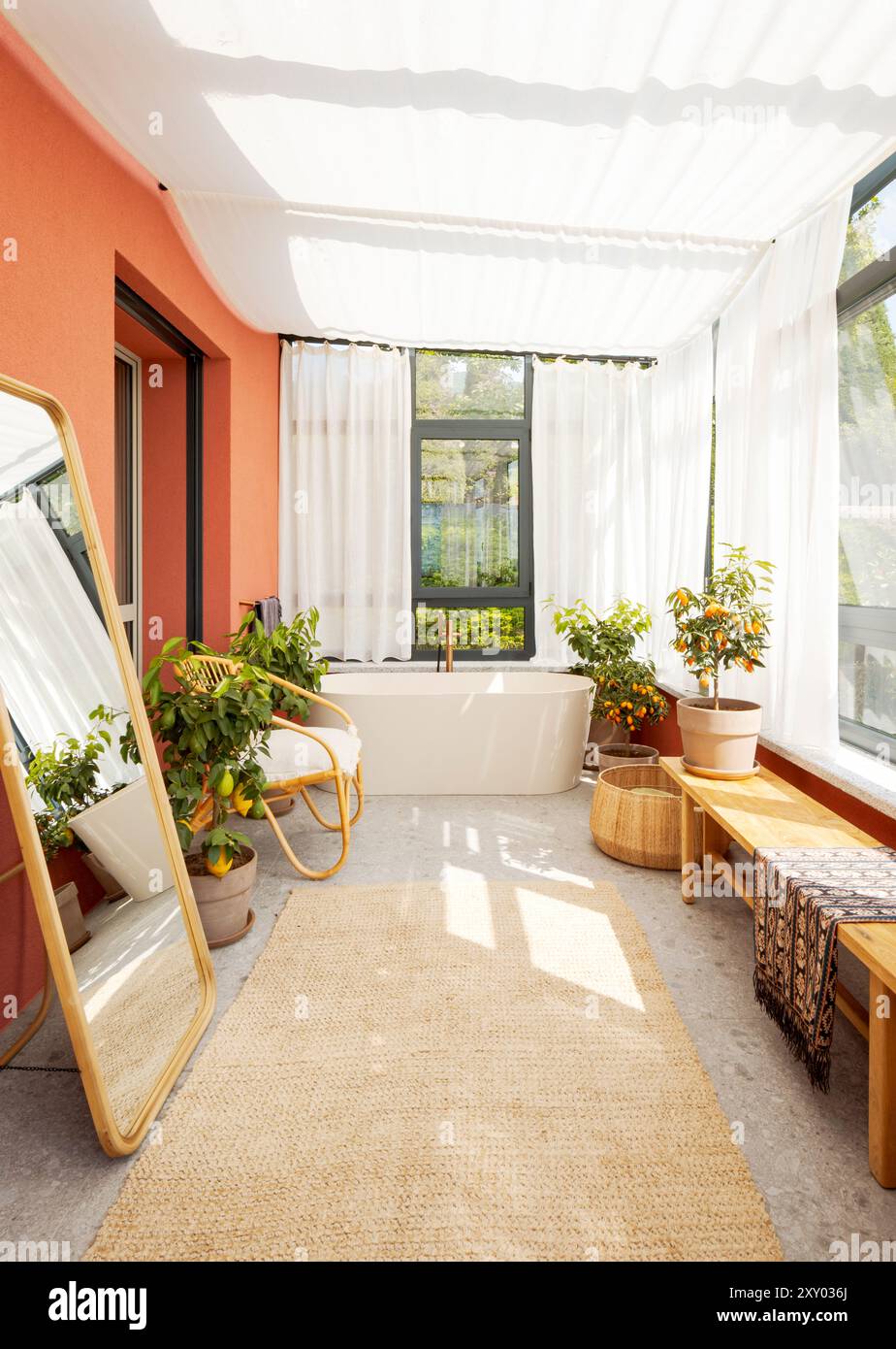 Frontal view of a large bathtub in a covered veranda with white ...