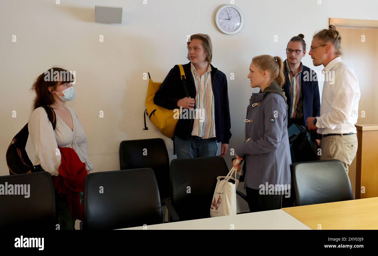 27 August 2024, Mecklenburg-Western Pomerania, Rostock: The five defendants from the Last Generation group take their seats in the courtroom of the district court before the start of the trial. The climate activists are on trial for alleged attempted coercion. They took part in a blockade of August-Bebel-Straße in Rostock in August 2023. Photo: Bernd Wüstneck/dpa Stock Photo